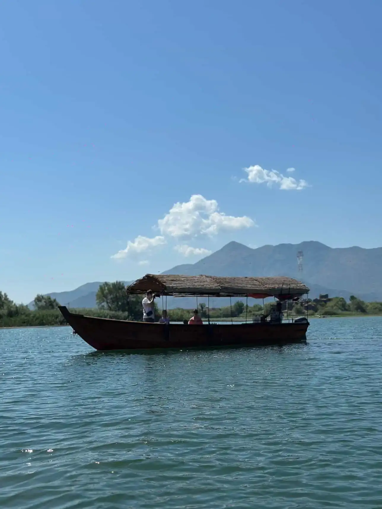 Traditional wooden boat departing Virpazar harbor for a Skadar Lake tour